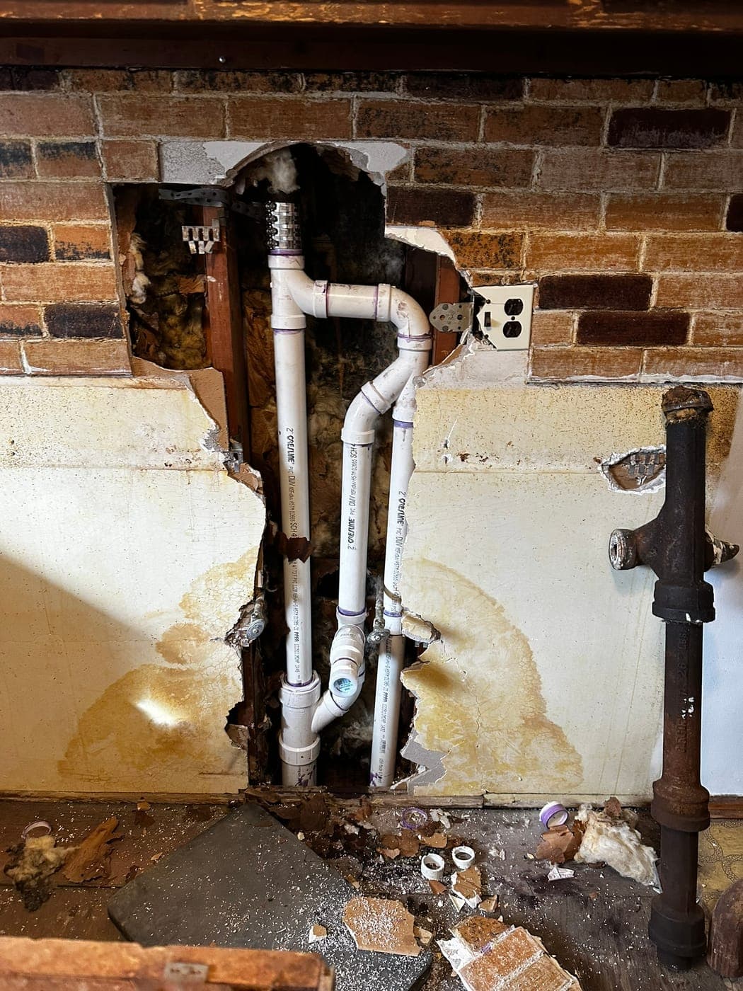 New PVC drain and vent lines roughed into a bathroom wall