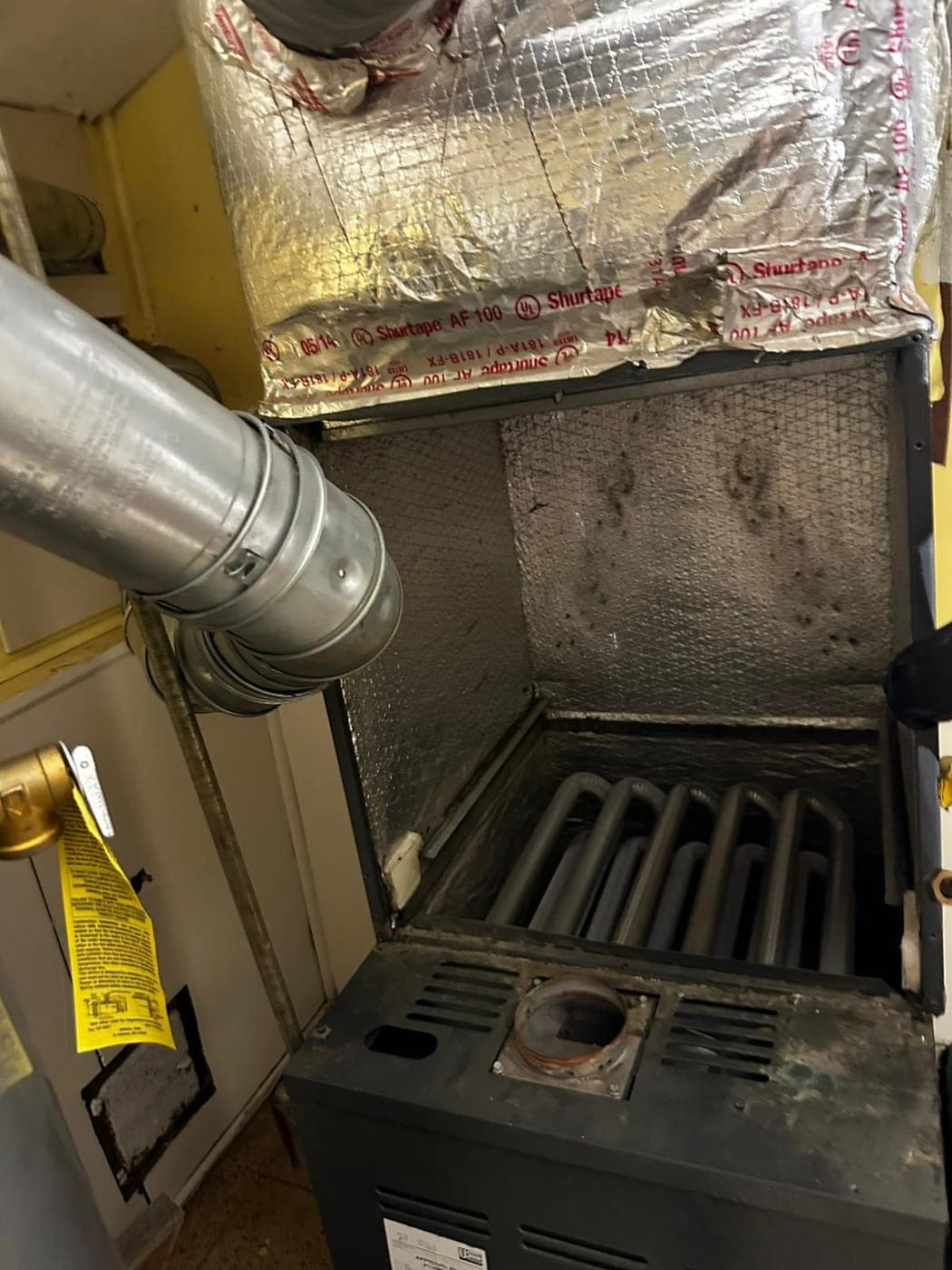 Inside of a gas furnace cabinet showing the burner assembly and controls