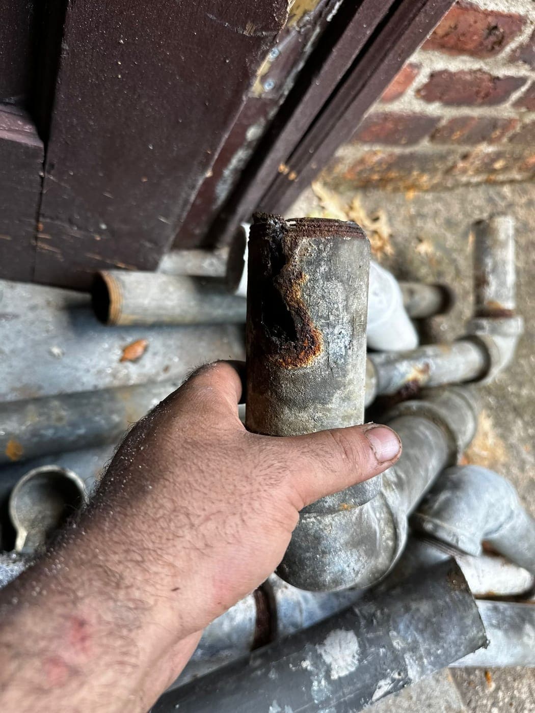 Section of old galvanized drain pipe nearly closed with scale
